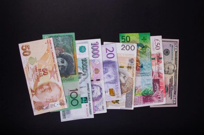 Several different currencies arranged on a black background