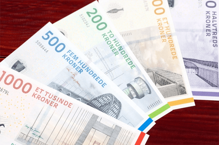 Danish Krone Bank notes on a cherry wood table