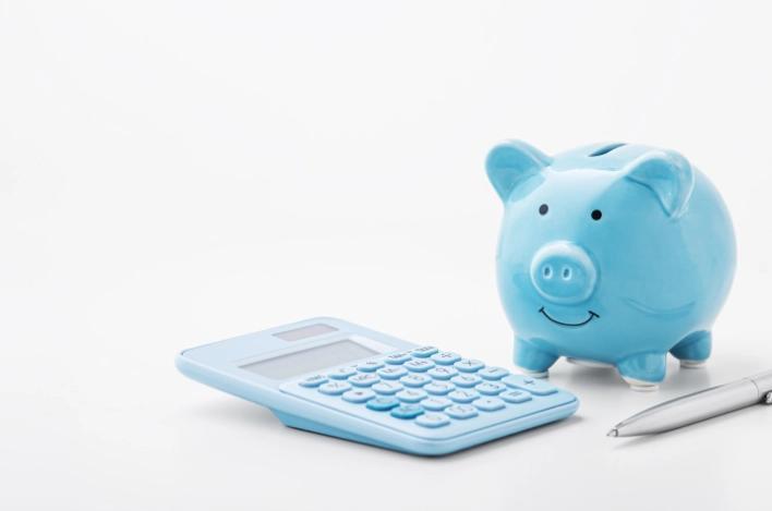 Piggybank with a calculator and a pen